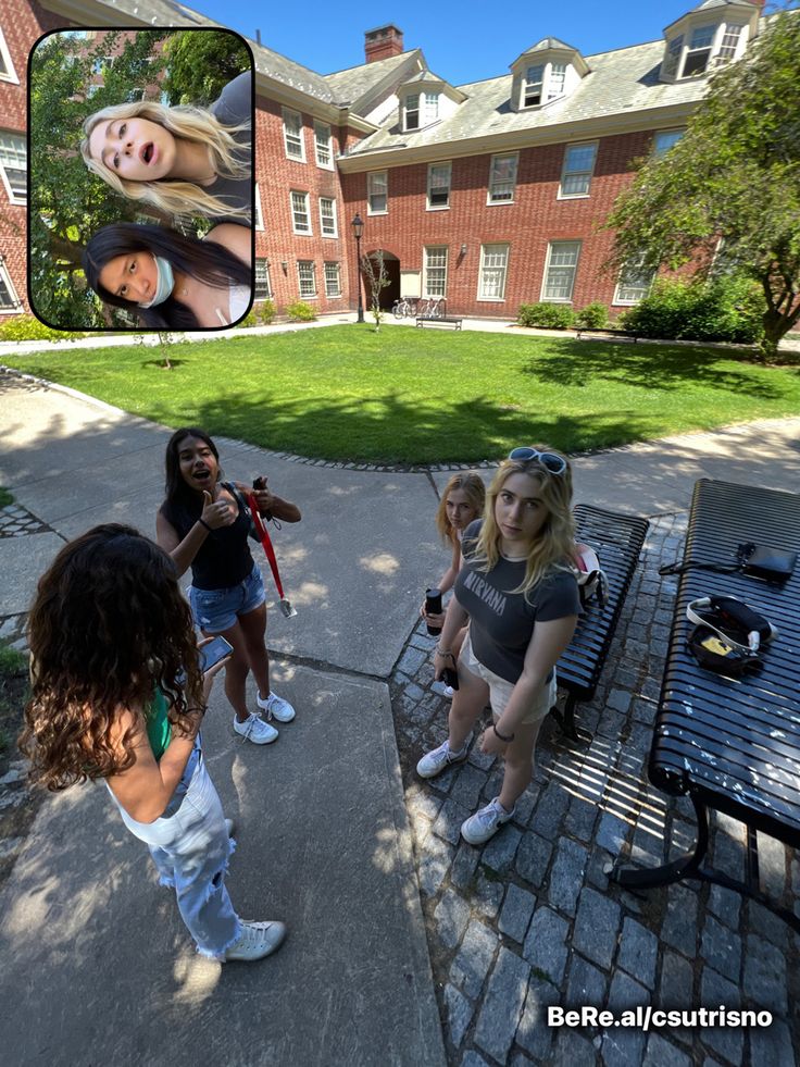 a group of young women sitting on top of a bench in front of a building