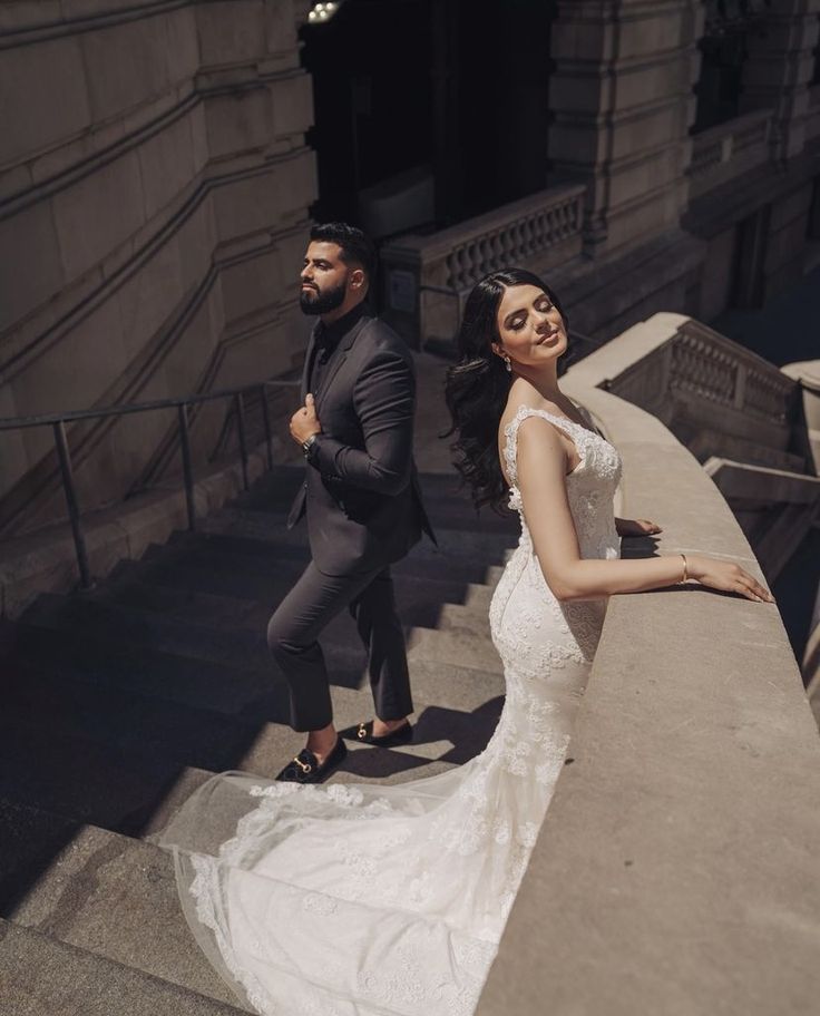 a bride and groom walking down the stairs