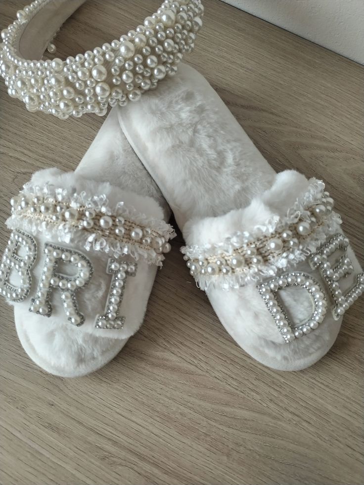 two pairs of white slippers with pearls on them