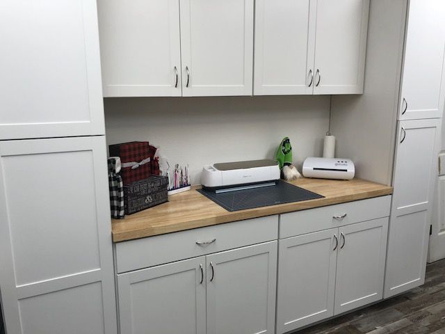 a kitchen with white cabinets and counter tops