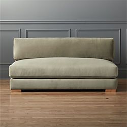 a couch sitting on top of a hard wood floor next to a gray painted wall