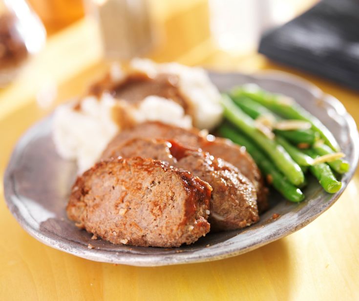 meatloaf with gravy and green beans on a plate