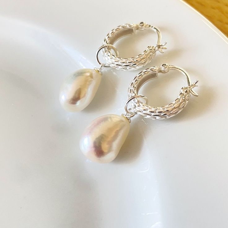 925 sterling silver Basket Weave Hoop earrings with a single Drop Pearl, each pearl is approx. 10mm x 15mm. The hoops are 10mm and the total drop is 30mm. choose either gold or silver from the drop down menu Pearls are the birthstone for June and have long been associated with purity, humility and innocence. So it may be said that the June birthstone meaning is "sweet simplicity."  Your item will arrive in an organza gift pouch, or choose a luxury gift box as illustrated from the drop down menu. Hoop Pearl Earrings, Silver Basket, Hoop Earrings Silver, Freshwater Pearl Earrings, Freshwater Pearls Earrings, Pearl Hoop Earrings, June Birthstone, Luxury Gift Box, Gift Pouch