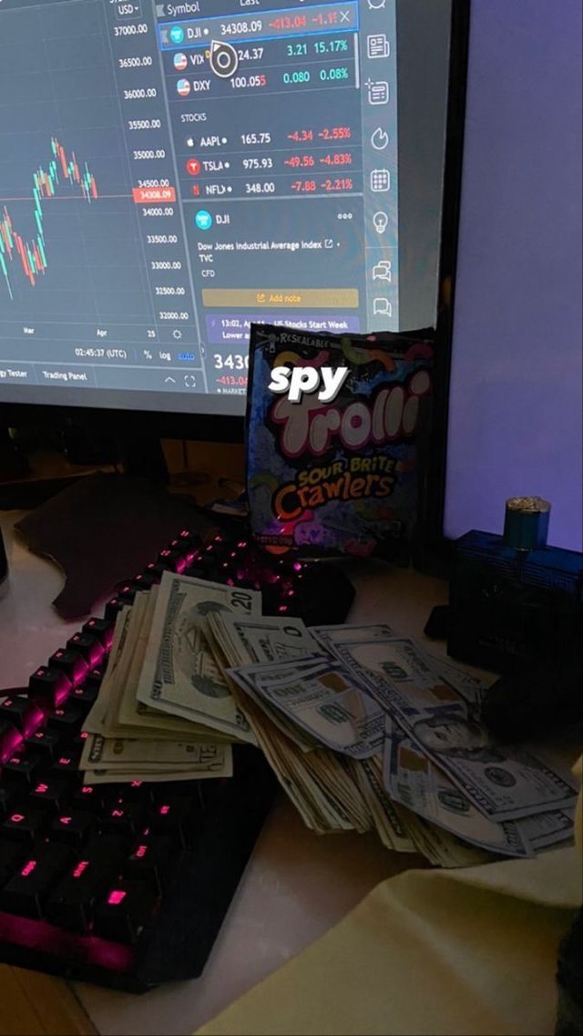 a pile of money sitting in front of a computer monitor