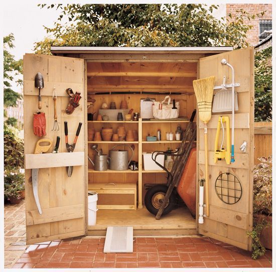 an outdoor storage shed with gardening tools in it