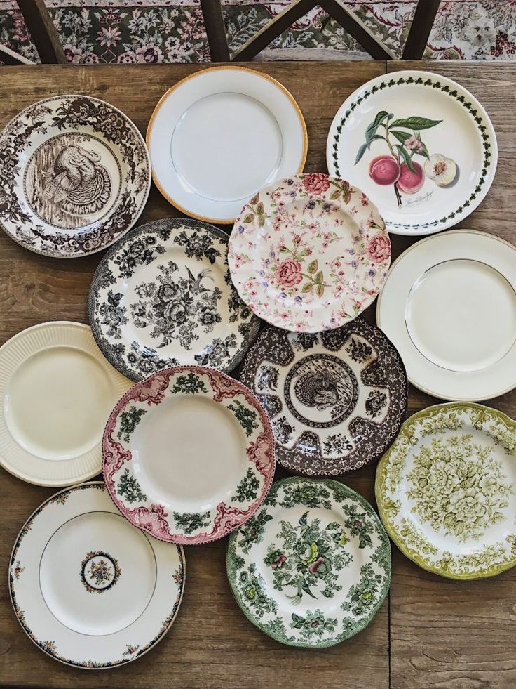 many plates are stacked on top of each other in different colors and designs, with one plate missing from the center