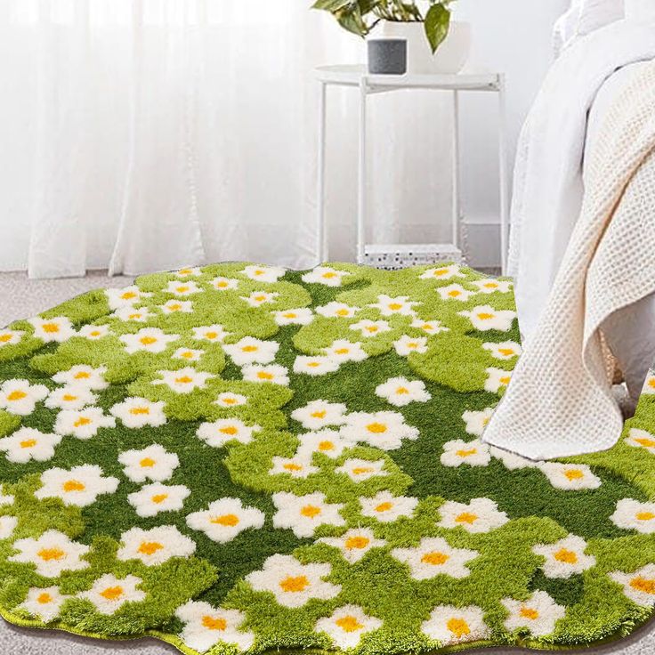 a green rug with white and yellow flowers on it in front of a bedroom window