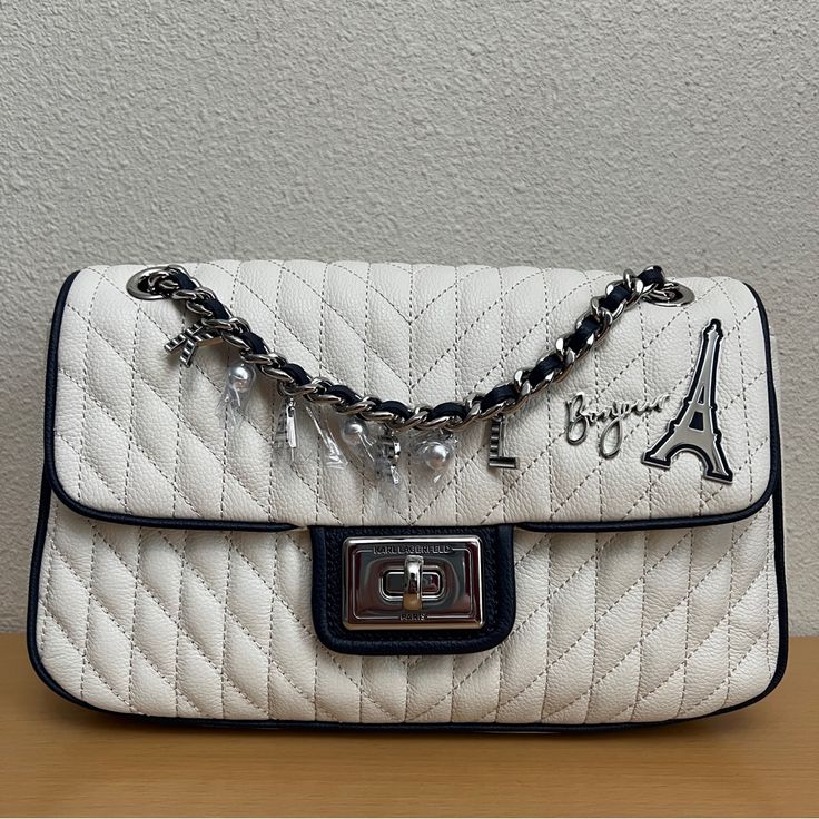 $248 Karl Lagerfeld Agyness Eiffel Tower Shoulder Bag White Navy New Twist-Lock Closure Blacktone Hardware One Outside Back Slip Pocket One Inside Zip Pocket One Inside Slip Pocket Lined Polyurethane Trim Textile Imported Dimensions: 10.5" W X 6" H X 2.5" D New With Tags Msrp: $248.00 100% Authentic See Pictures For Details. Item Is Sold As Is. Color May Differ In Actuality Due To Lighting. Thank You For Visiting My Store. Please Feel Free To Ask Any Questions. Luxury White Flap Bag With Removable Pouch, White Formal Flap Bag With Branded Hardware, Formal White Flap Bag With Branded Hardware, Designer White Flap Bag With Detachable Strap, Luxury White Flap Shoulder Bag, Luxury White Shoulder Flap Bag, White Flap Bag For Travel With Dust Bag, Designer White Flap Bag For Evening, White Rectangular Flap Bag With Branded Hardware