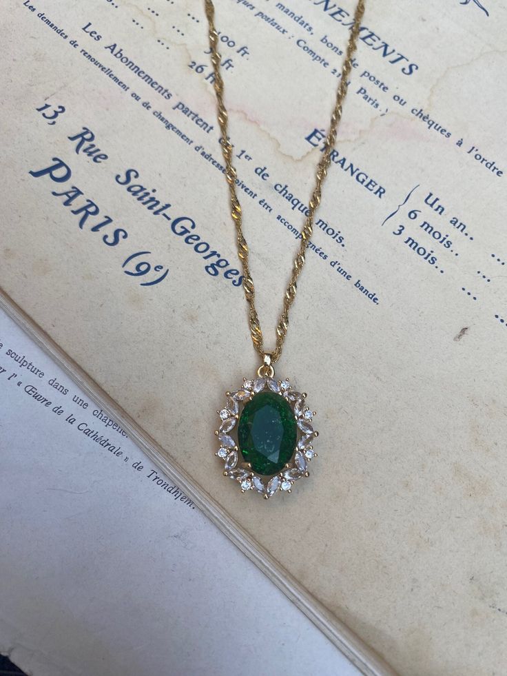 Gold-plated over brass vintage inspired pendant with crystals and a large oval emerald green measuring 2.4 cm 3 cm. Hung on a gold-plated over stainless steel twisted chain measuring 18 inches. Comes in a black velvet cushioned box as seen in last photo. Free of charge. INTERNATIONAL BUYERS please choose the tracking option if you would like your order to be tracked. FREE tracking upgrade with 3 items or more purchased. JEWELLERY CARE please don't wear plated jewellery in the shower, bath or swi Emerald Necklace Vintage, Luxury Oval Pendant Emerald Necklace, Vintage Gold Emerald Necklace For Formal Occasions, Vintage Gold Necklace With Emerald, Vintage Gold Necklace For May Birthstone, May Birthstone Gold Vintage Necklace, Gold Emerald Oval Pendant Jewelry, Vintage Emerald Necklace With 17 Jewels As A Gift, Vintage Emerald Pendant Necklace Gift