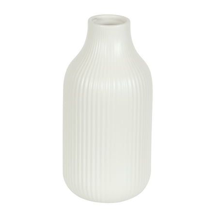 a white vase sitting on top of a table