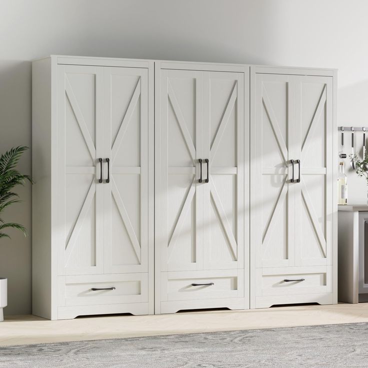 a large white cabinet sitting next to a potted plant