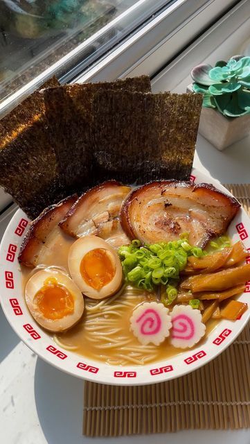 a bowl filled with food next to a window