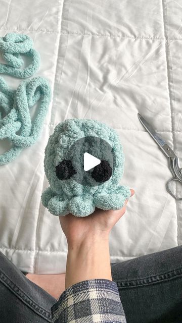 someone is holding up a knitted octopus toy