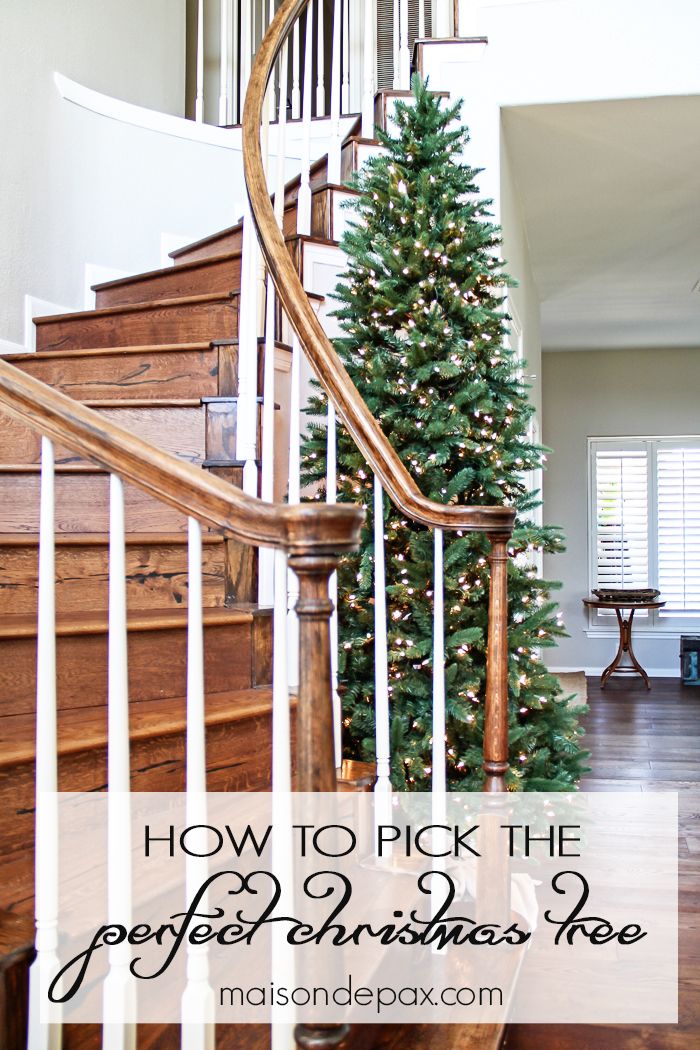 a christmas tree sitting on top of a wooden banister