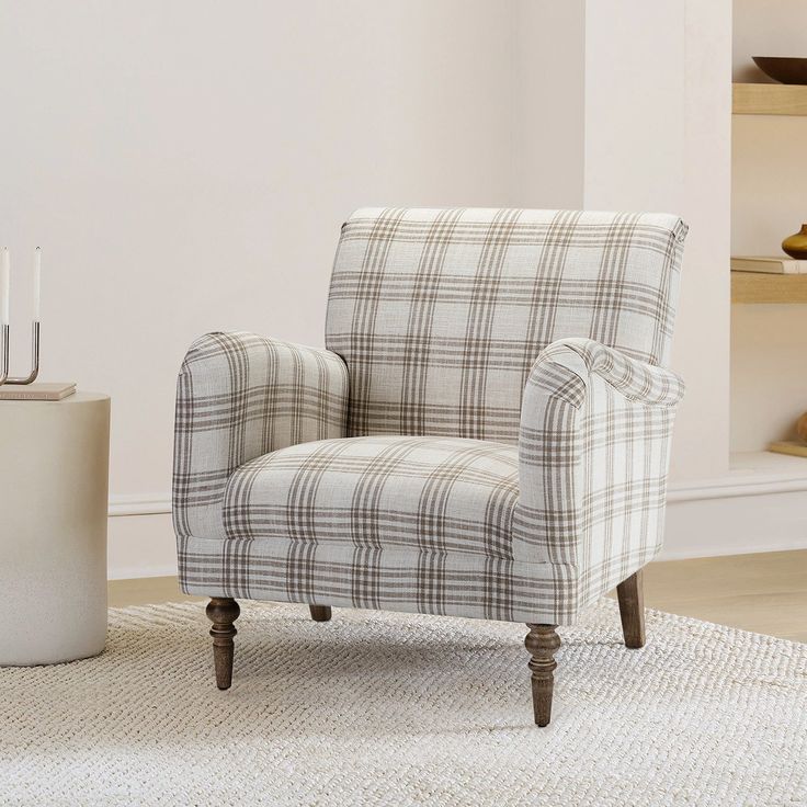 a chair sitting on top of a rug next to a white vase with candles in it