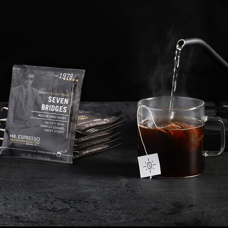 a glass cup filled with liquid next to a stack of business cards on a table