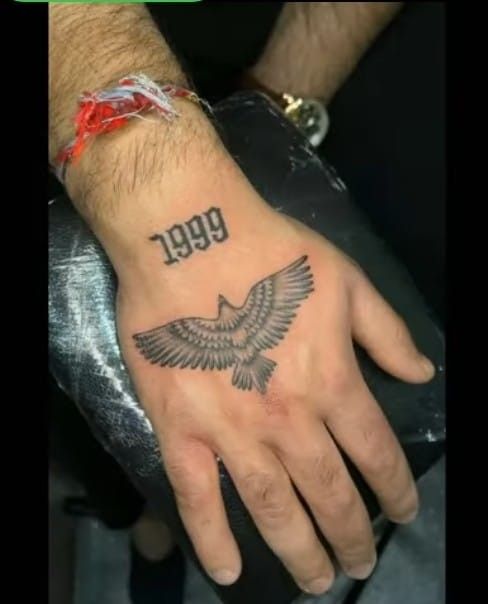 a man's hand with an eagle tattoo on it