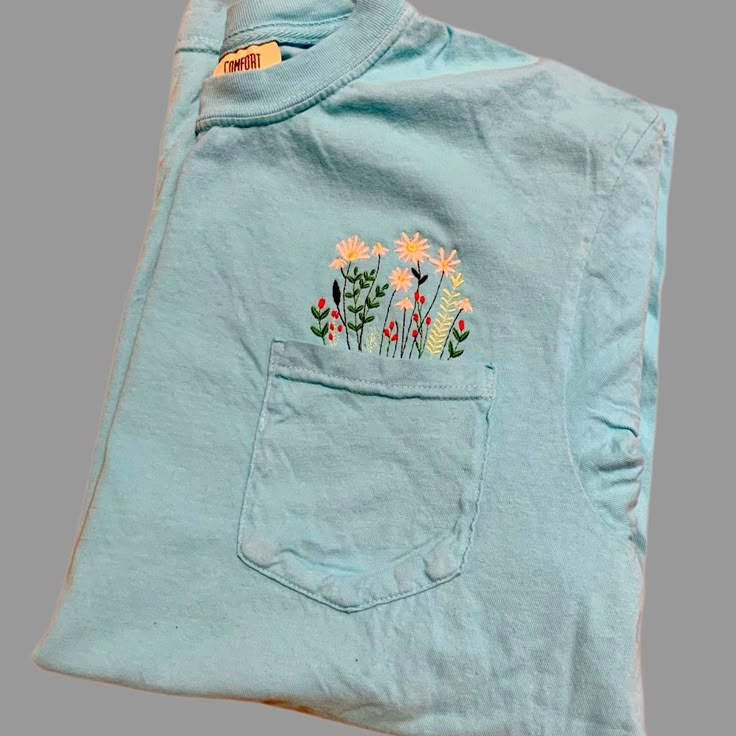 a blue shirt with flowers in the pocket