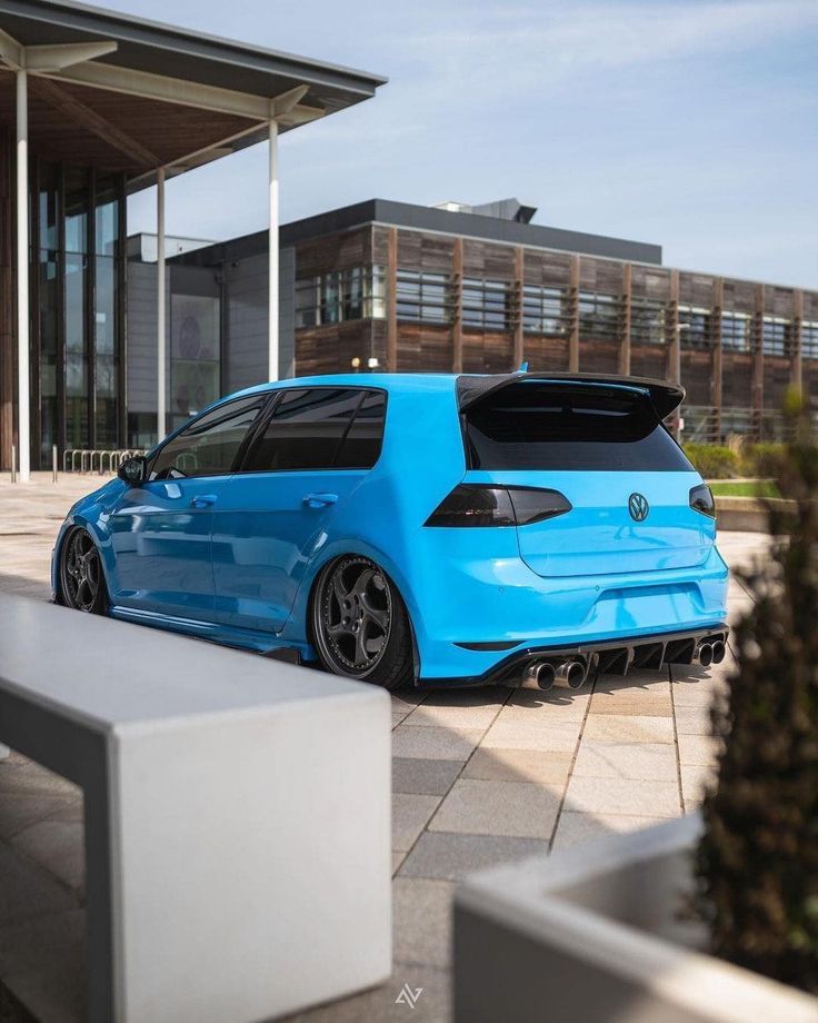 a blue car parked in front of a building