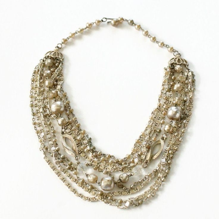 Vintage Layered Multi Chain Necklace with Faux Pearls. This choker style necklace features 8 different chains, a mix of plain chains to faux pearls. Adjustable. Hook clasp. Circa 1950's Multi-strand Layered Pearl Chain Necklace For Parties, Multi-strand Layered Pearl Necklace For Party, Pearl Multi-strand Necklace For Parties, Multi-strand Metal Necklace With Pearl Chain, Multi-strand Pearl Chain Beaded Necklaces For Party, Glamorous Gold Pearl Necklace For Evening, Multi-strand Metal Pearl Chain Jewelry, Silver Multi-strand Layered Necklace With Pearl Chain, Silver Multi-strand Pearl Chain Necklace