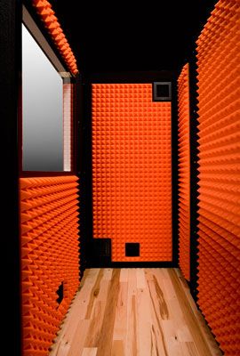 an orange room with black walls and wooden flooring is shown in this image from the inside