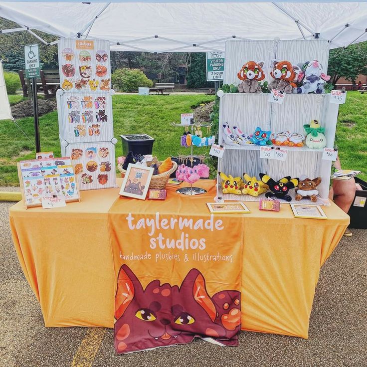 the table is set up with pictures and other items for sale at the fairground