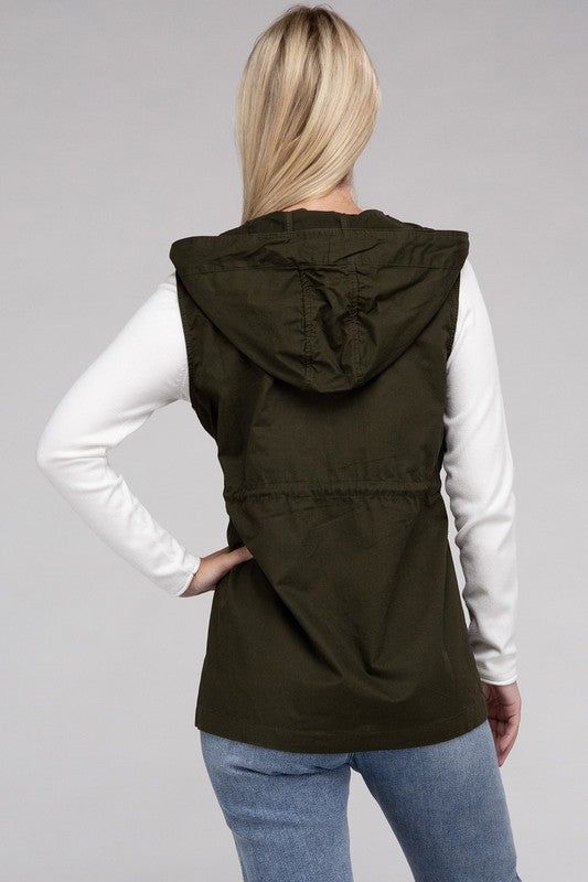 A versatile fashion piece that seamlessly blends style and utility. This vest boasts a convenient zipper and snap-button closure, ensuring ease of wear, while the adjustable drawstring waist provides a personalized, flattering fit. With practical pockets, it's a fashionable yet functional addition to any outfit, making it perfect for both casual and statement looks. Model is wearing a SmallModel SpecsHeight: 5'8"Bust: 34D Waist: 24"Hips: 37"*Color may vary slightly due to monitor resolutionMade Military Hoodie, Hoodie Vest, Outfit Making, Snap Button, Drawstring Waist, Zipper, How To Wear, Color