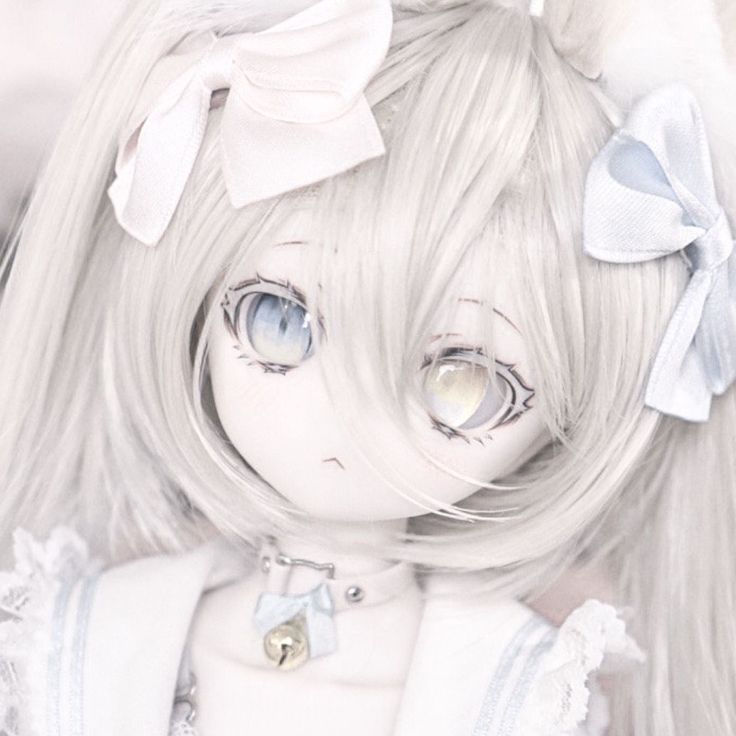 a doll with white hair and blue eyes wearing a bow around her head is looking at the camera