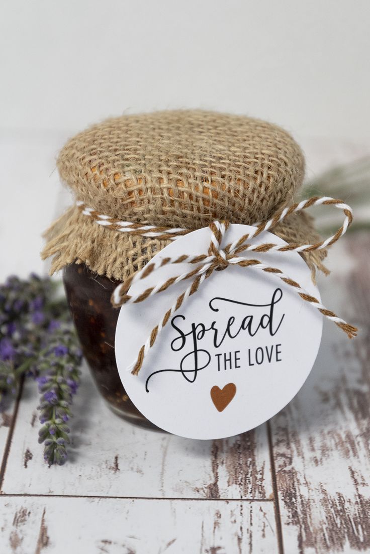 a jar filled with jam sitting on top of a wooden table next to lavender flowers