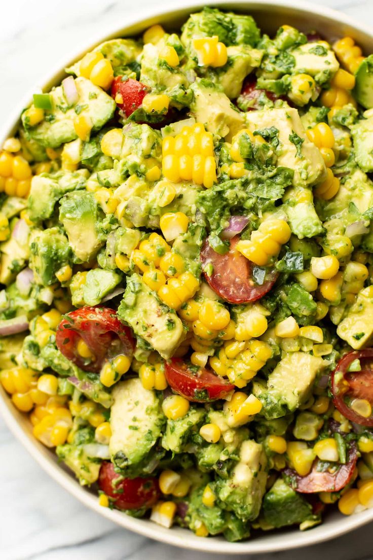 a bowl filled with corn and avocado salad