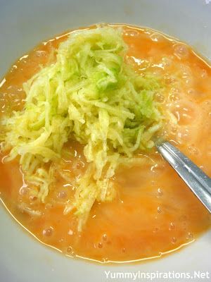 a white bowl filled with soup and cabbage next to a spoon on top of it