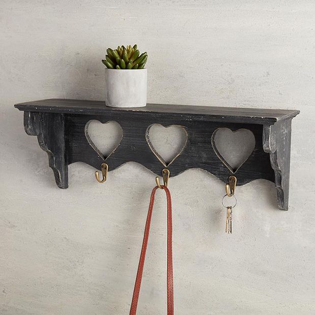 a wooden shelf with hearts hanging on it and two key hooks attached to the wall