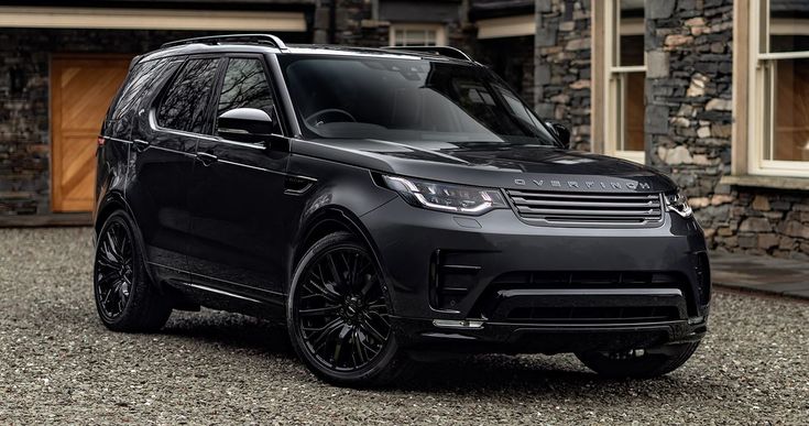 a black range rover parked in front of a house