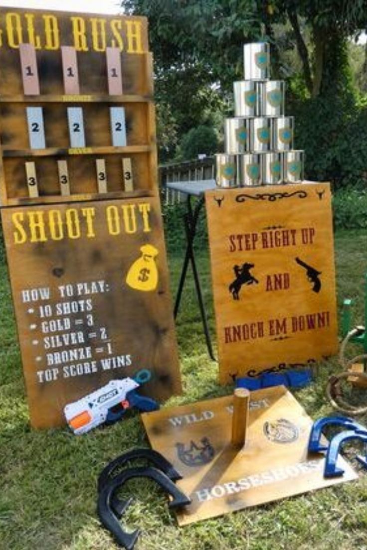 an assortment of items are on display in the grass near a sign that says shoot out