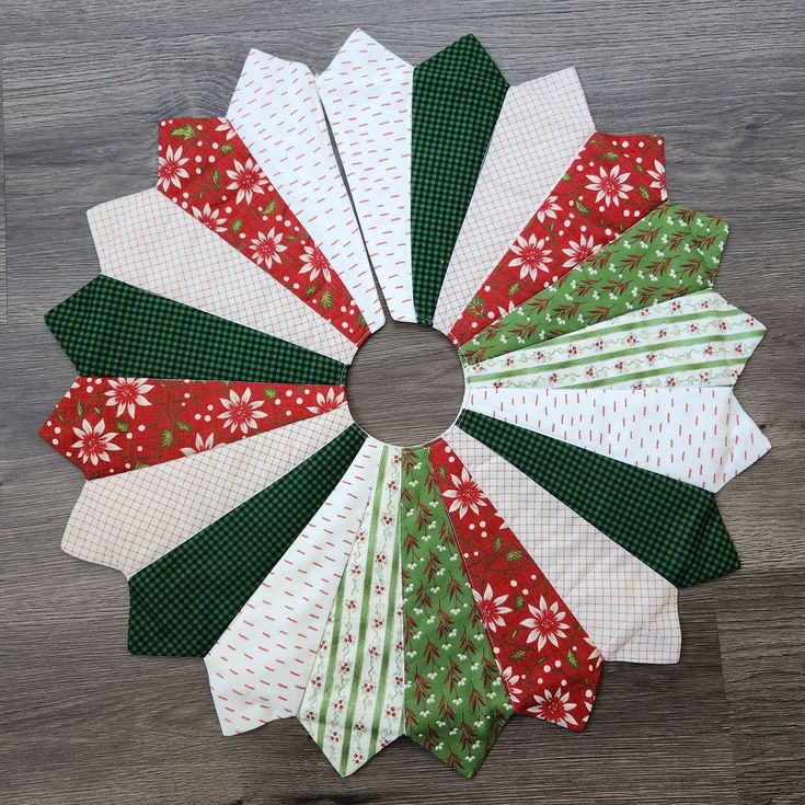 a christmas wreath made out of paper on top of a wooden table