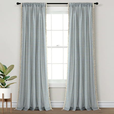 a white and blue striped curtain hanging in front of a window next to a potted plant