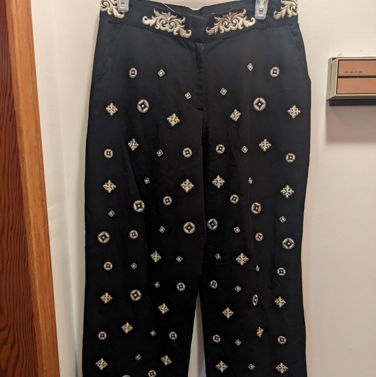 Beautiful Linen Blend Pants With Gold Embroidered Diamond Patterns And Accented Waist. Black Color. Black Embroidered Wide-leg Bottoms, Black Embroidered Wide Leg Bottoms, Black Embroidered Straight Leg Pants, Black Wide Leg Embroidered Bottoms, Elegant Embroidered Black Bottoms, Elegant Black Embroidered Bottoms, Fitted Embroidered Black Bottoms, Embroidered Fitted Pants For Workwear, Fitted Embroidered Pants For Workwear