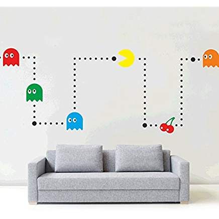 a couch sitting in front of a white wall with pacman stickers on it