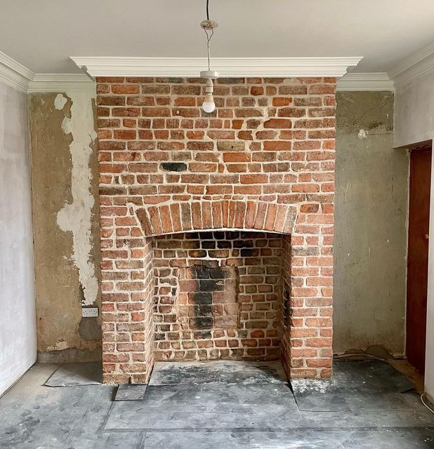 an empty room with a brick fire place