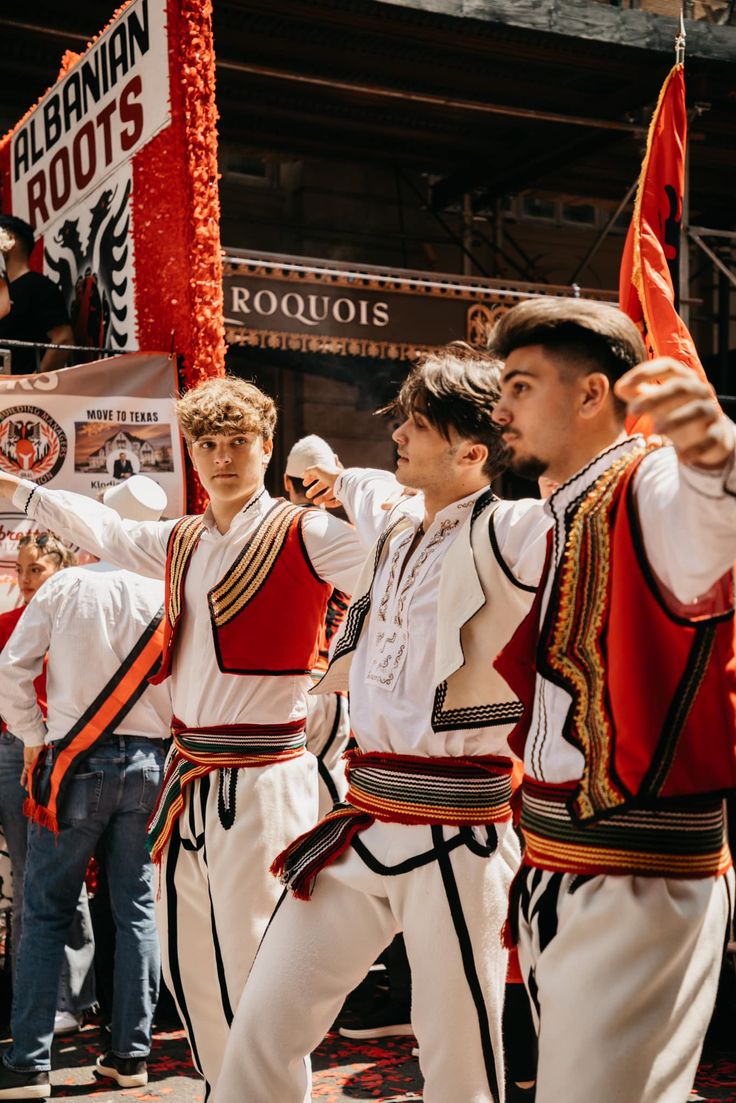 a group of young men standing next to each other on top of a stage with flags