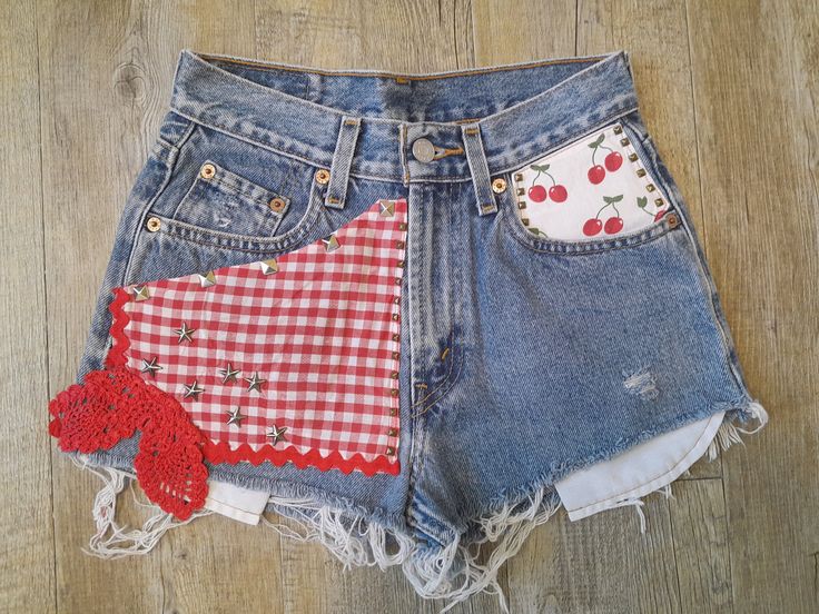 "These petite sized high waisted vintage Levi jean shorts were customised with a realy country look, reminding me of Daisy Duke and Jessica Simpson.   It features red checked ginham, vintage red crochet lace, cherries to the front pocket, with ric rac trim front and back.  Metal studs add some spunk.  So definitely one of a kind.  The vintage leather tag reads  Waist 25\" (64cm).   Measurements taken laid flat, so please double as needed. Waist-  32 cm - 12.5\" Front Rise- 27 cm - 10.5'' (From top of waist to crotch seam.) Inseam  4 cm - c. 1.5''   Length Down Front - 24 cm - 9.5\" Hips 47cm - 18.5''" Vintage High-waisted Jean Shorts For Spring, Fitted Patchwork Shorts For Summer, Vintage Fitted Cutoff Jean Shorts, Fitted Vintage Cutoff Jean Shorts, Retro Cutoff Jean Shorts For Spring, Vintage Fitted Jean Shorts With Pockets, Vintage Jean Shorts With Pockets For Spring, Vintage Jean Shorts For Spring, Vintage Fitted Jean Shorts