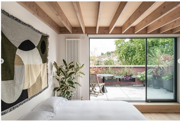 a bed sitting under a wooden ceiling next to a sliding glass door in a bedroom