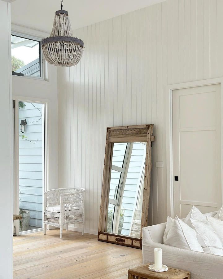 a living room filled with furniture and a large mirror on the wall next to a window