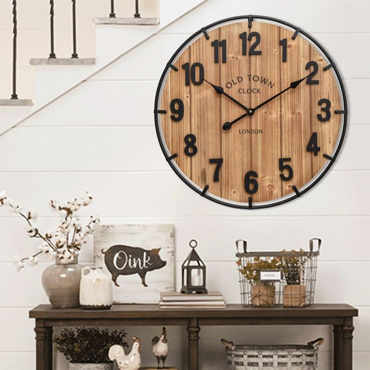 a clock that is on the side of a wall next to some baskets and flowers