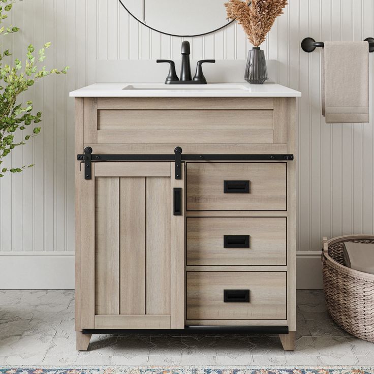 a bathroom with a sink, mirror and towel rack next to a basket on the floor