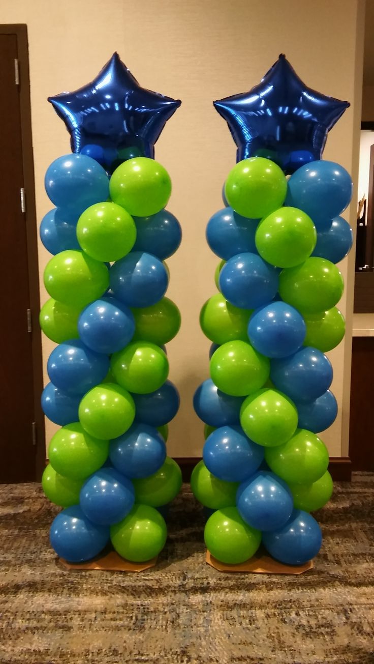 two tall blue and green balloons in the shape of stars on top of each other