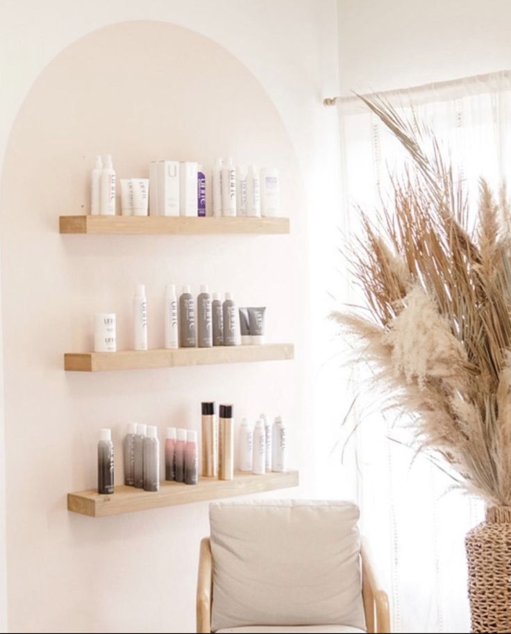 a vase with some flowers in it next to shelves filled with personal care products on the wall