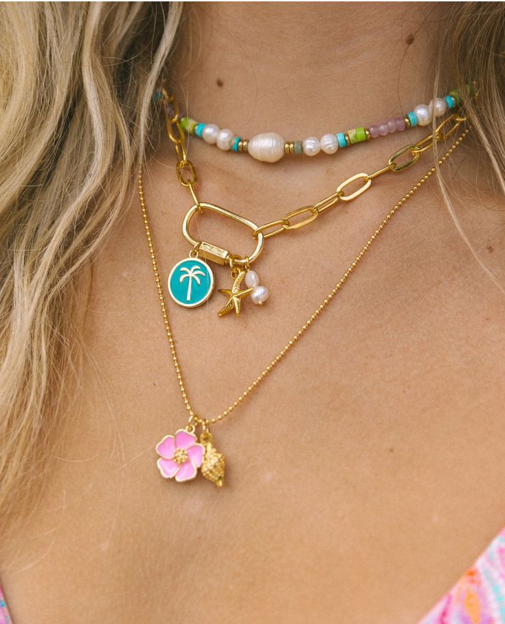 The Hibiscus Necklace is the necklace of the summer! The bright enamel Hibiscus charm paired with a gold conch shell on a ball chain is the perfect representation of the whimsical free spirit of summertime. 24k gold plated tarnish free 19” Cheap White Charm Necklaces For The Beach, Cheap Casual Summer Shell Necklace, Cheap Adjustable Necklaces With Starfish Charm, Summer Vibe Jewelry, Cheap Beachy Shell Necklace As A Gift, Cheap Playful Beach Necklaces, Luxury Shell-shaped Beach Necklaces, Preppy Gold Necklaces, Small Business Jewelry Photography