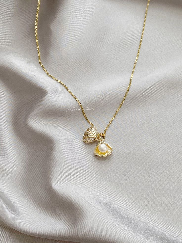 "△ DETAILS * 100% Genuine natural freshwater pearls, real pearl * Natural white color button shaped pearls, 5-5.5mm size, AAAA grade * 14K gold plated seashell/shell clam/oyster, with faceted cubic zirconia * 18K gold vermeil sterling silver chain, 18 inches (45cm) length * Delicate and daily wear necklace, perfect for yourself or as a gift * Ready for gifting, packed in a beautiful jewelry box * Handmade in USA ♥ Pearl Size: 5-5.5mm ♥ Pearl Shape: Button ♥ Pearl Color: White ♥ Chain Length: 18 Pearl In Shell Necklace, Pearl Clam Necklace, Cute Pearl Jewelry, Pearl White Shell Pearl Necklace With Pendant, Pearl White Shell-shaped Necklace With Pearl Pendant, Gold Pearl Shell Necklace With Pearl Drop, Shell-shaped Pearl Necklace With Pearl Pendant, Shell-shaped Pearl Charm Necklaces, Pearl Drop Shell Pearl Necklace