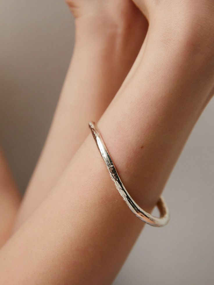 Editor's Notesgemma alus design presents a textured silver bangle. It is an excellent item to highlight your wrist and arm. - Textured bangle- Made of silver 925- Curved design- Causal and unique mood Measurements(in.)One Size- Size: 2.56 in. (W) * 2.09 in. (H) Composition & Care- Material: 925 Silver- Plated products may discolor over time due to their nature.- Please be careful that discoloration may proceed faster in chemical substances, water, and heat.- As all j Modern Hammered Bangle Bracelets, Hand Forged Elegant Bangle, Luxury Hammered Bangle Bracelet, Minimalist Hammered Bangle Bracelet, Elegant Hammered Sterling Silver Bangle Bracelet, Elegant Hammered Sterling Silver Bangle, Luxury Hammered Bangle, Minimalist Hammered Bracelet Bangle, Hammered Minimalist Bangle